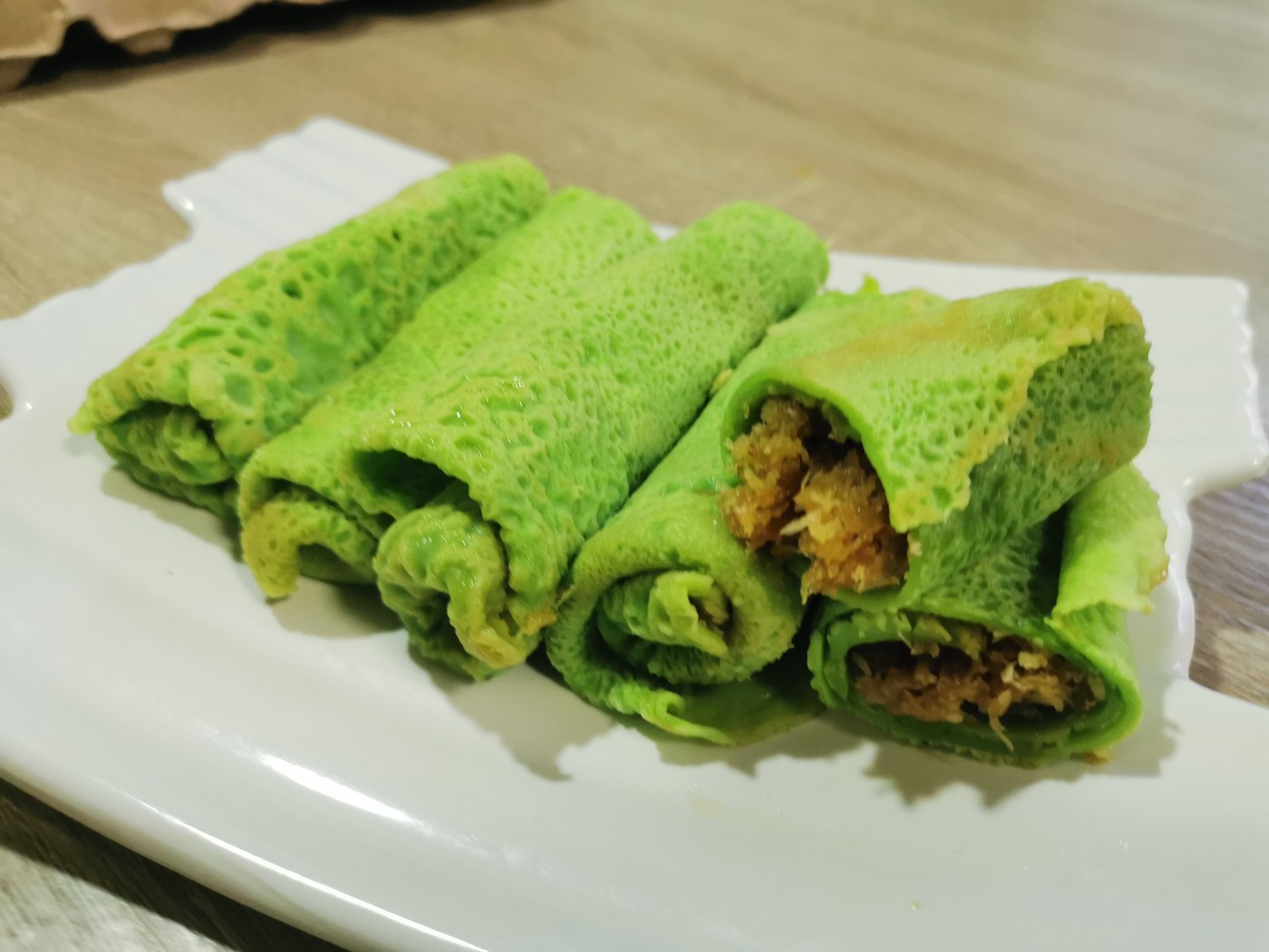 Kuih Ketayap, a pandan crepe rolled with grated coconut filling